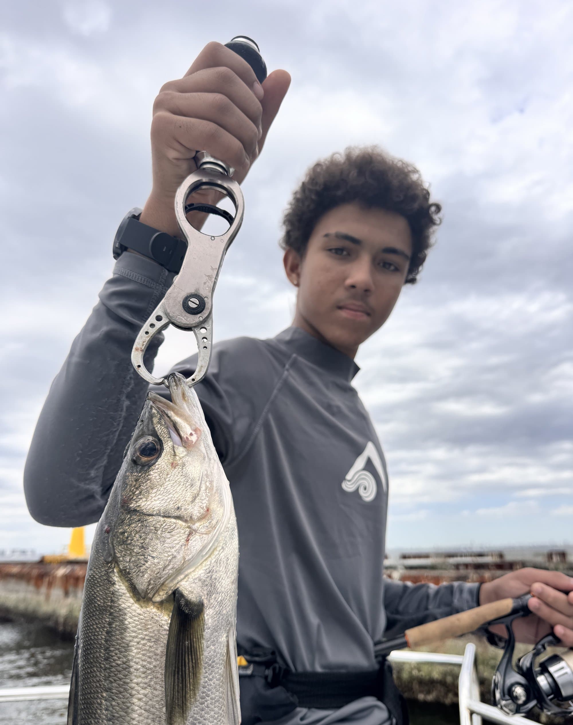 Reyaan holding up a fish with a lip gripper tool